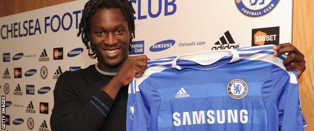 Romelu Lukaku holding up a Chelsea shirt