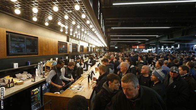 Fans drink at Tottenham Hotspur Stadium