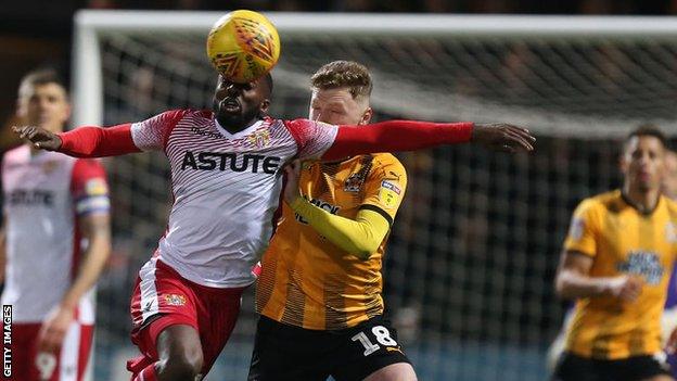 Stevenage's Emmanuel Sonupe get his head to the ball first