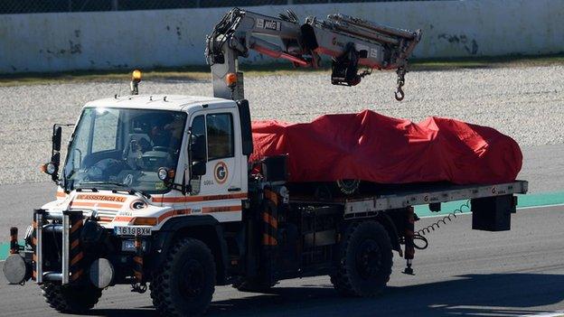 Sebastian Vettel's car is taken away on a truck during pre-season testing in Barcelona