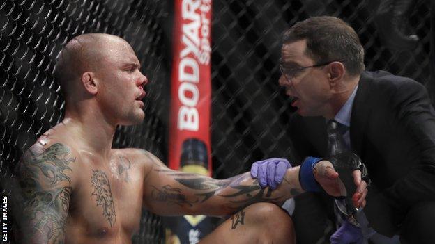 A doctor checks out a bloodied Anthony Smith during the fight