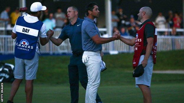 Alex Noren and Jason Day shake hands with their respective caddies