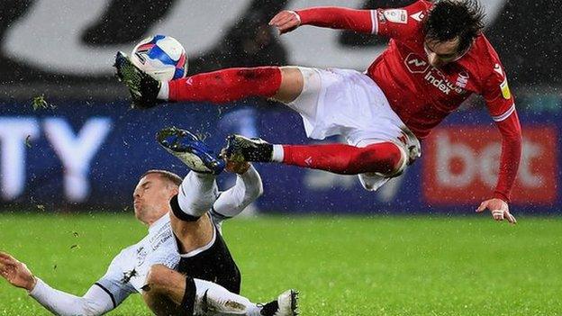 Swansea's Jake Bidwell slides in on Nottingham Forest's James Garner