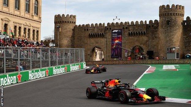 Max Verstappen and Daniel Ricciardo drive past the medieval castle in the city of Baku