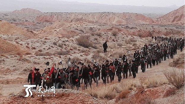 Chinese state media pictures show security forces searching a remote area of rugged terrain in Xinjiang