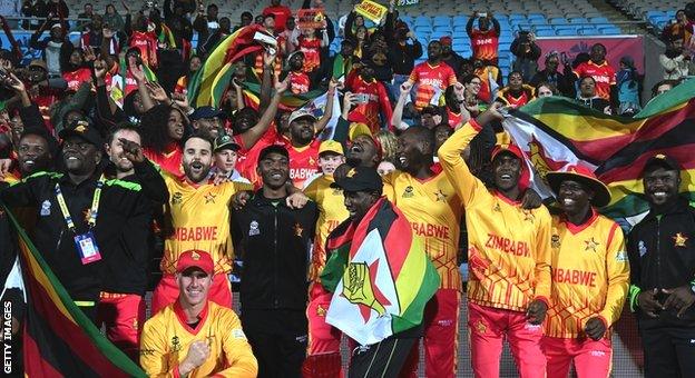 Zimbabwe players and staff celebrate with travelling fans after beating Scotland in Hobart