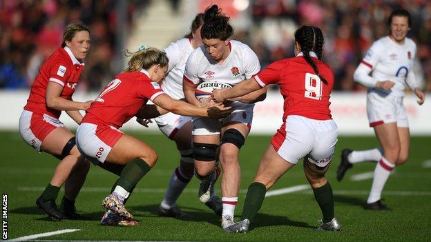 Abbie Ward runs through Wales tackles