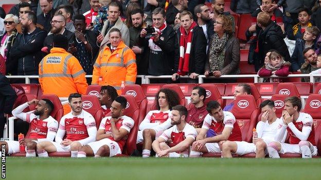 Arsenal players look despondent on the bench after drawing with Brighton