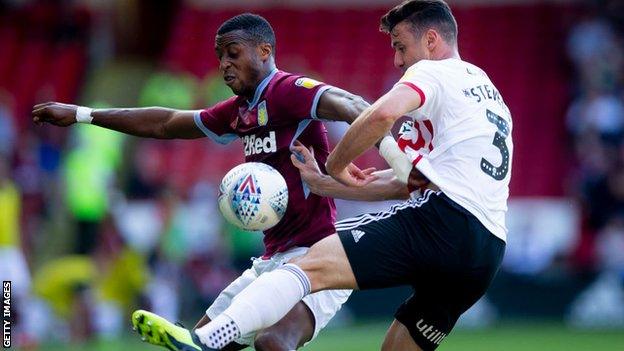 Aston Villa's Jonathan Kodjia battles with Sheffield United's Enda Stevens