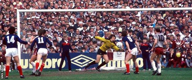 Albert Kidd (number 14) watches his shot fly past Hearts goalkeeper Henry Smith at a packed Dens Park