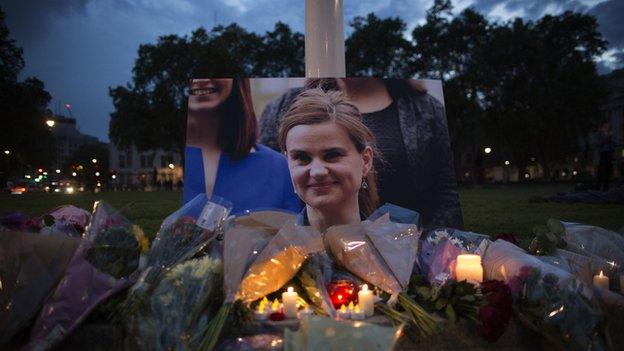 Flowers surround a picture of Jo Cox during a vigil in Parliament Square on 16 June 2016