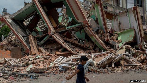 A man walks past rubble following the second quake on 13 May, 2015