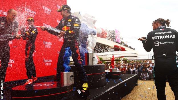 Lewis Hamilton, Max Verstappen and Sergio Perez engage in the champagne shower on the podium