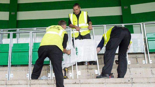 Workers install the new safe-standing barriers at Celtic Park