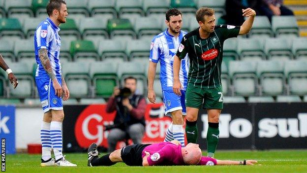 David Fox (24) of Plymouth Argyle waves the physio on after a collision between referee Kevin Johnson and Jimmy Spencer