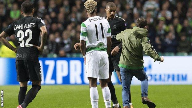 A fan runs towards PSG star Kylian Mbappe