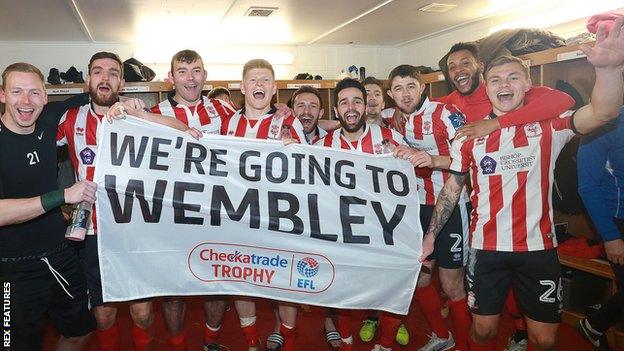 Lincoln City players celebrate beating Chelsea Under-21s on penalties in the EFL Trophy