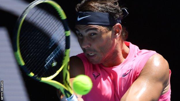 Rafael Nadal in close-up, watching the ball off his racquet as he plays a shot