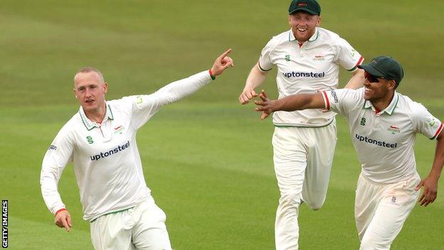 Callum Parkinson (left) celebrates taking a wicket for Leicestershire