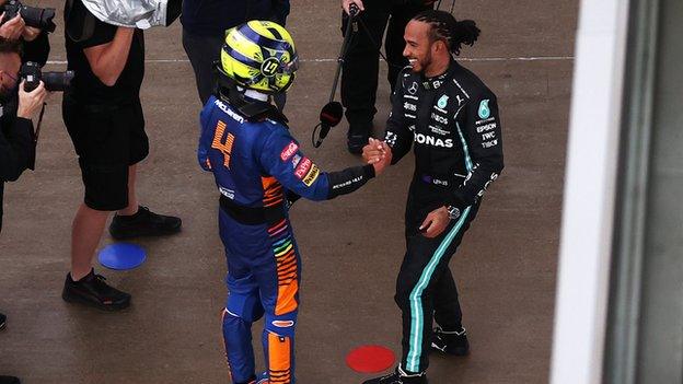 Lando Norris shakes hands with Lewis Hamilton