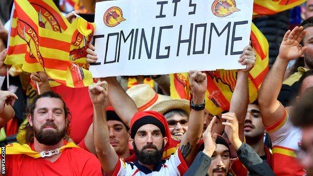 Catalans fan with an 'It's coming home' sign