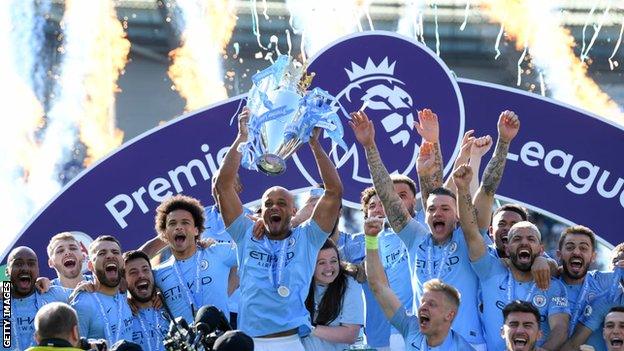 Manchester City lift the Premier League trophy following victory at Brighton