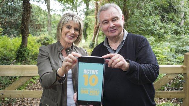 Ruth Langford and Eamonn Holmes holding a large iphone and smiling