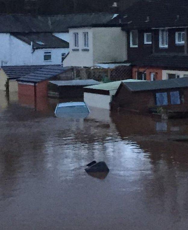 Car almost completely submerged in front of houses in Carlisle