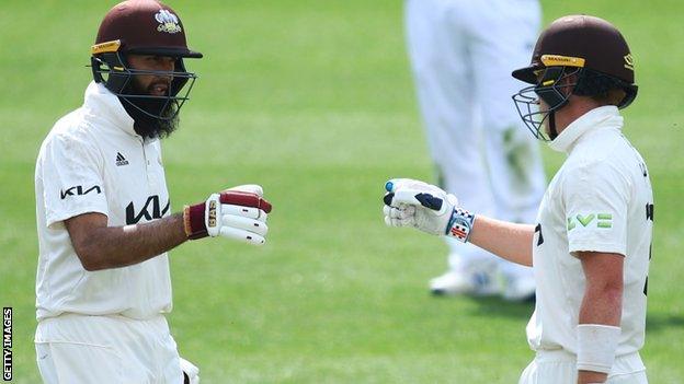 Surrey batters Hashim Amla (left) and Ollie Pope fist bump