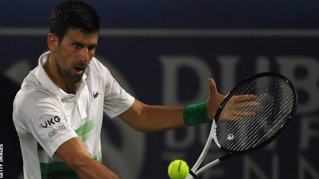 Novak Djokovic returns a ball against Karen Khachanov in Dubai