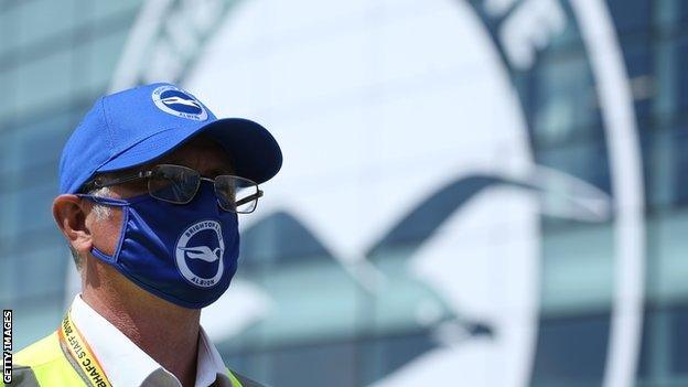 Brighton steward wearing a mask