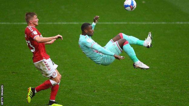 Swansea's Marc Guehi tries an overhead kick as Taylor Moore watches on