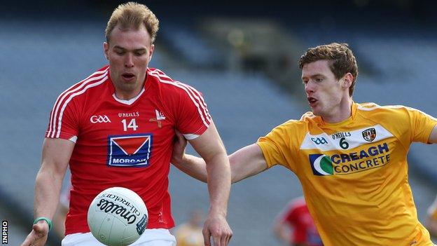 Louth's Conor Grimes is challenged by Antrim's Martin Johnston