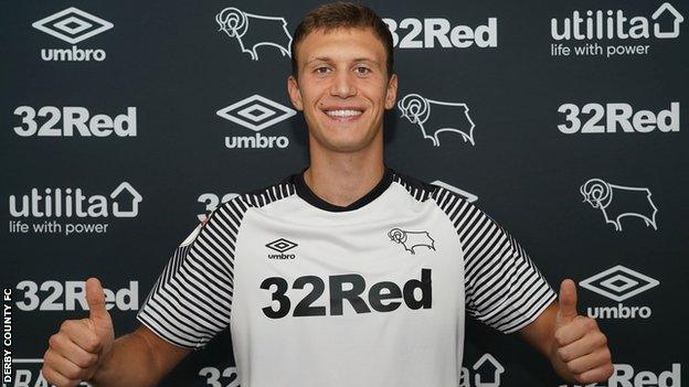 Krystian Bielik poses in a Derby shirt