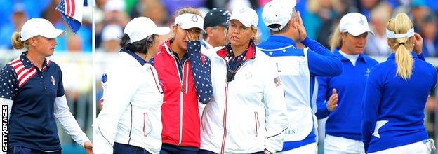 Alison Lee of the United States is comforted by Nancy Lopez (l) and Wendy Ward (r) United States assistant captains on the 18th green after Lee's error in picking up her ball on the 17th hole before it had been conceded by her European Team opponents Suzann Pettersen and Charley Hull