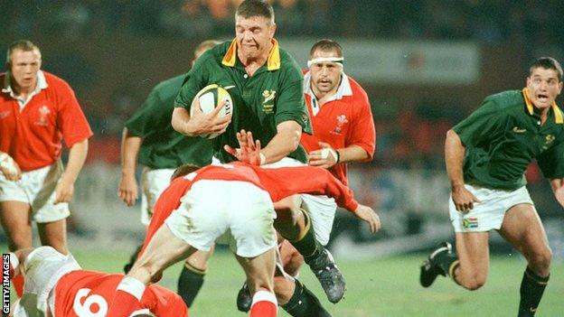 South African lock Krynauw Otto attempts to break past Wales players Paul John (ground) and Garan Evans (front)