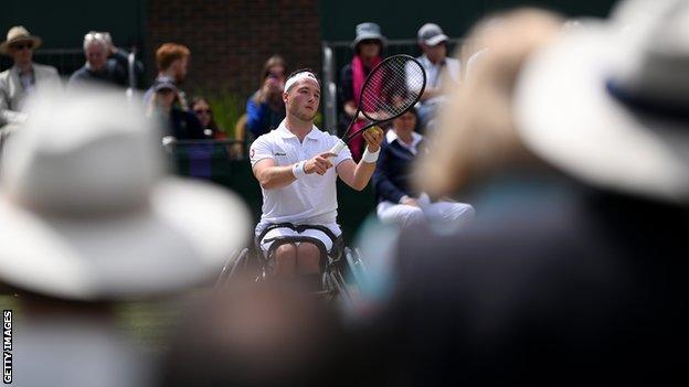 Alfie Hewett serves as fans watch