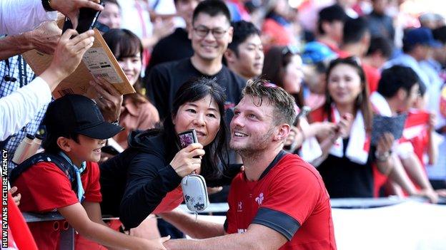 Wales rugby player Dan Biggar poses for a selfie with some of the 15,000 fans who turned up to watch the team train at Kitakyushu Stadium on 16 September