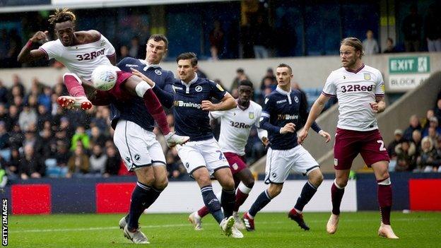 Tammy Abraham volleys ahead Villa despite the attentions of Millwall defender Jake Cooper