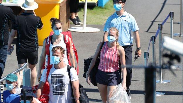 Tennis players in masks walking to training