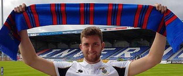 Matthew Elsdon holds aloft a Caley Thistle scarf