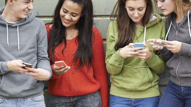 Teenagers checking mobile phones