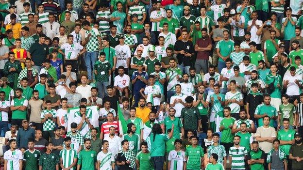 Al Ahli Triopli fans watch from the stands