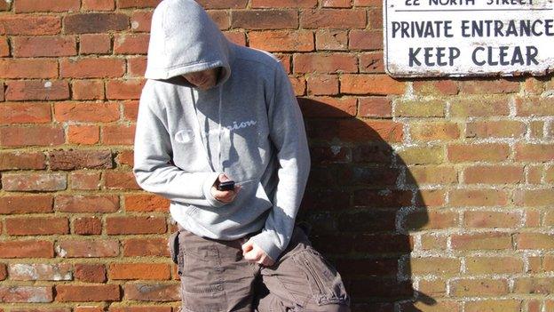 Man in a hoody using a mobile phone