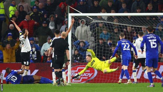 Uche Ikpeazu scores his third goal for Cardiff as Curtis Davies appeals for a foul