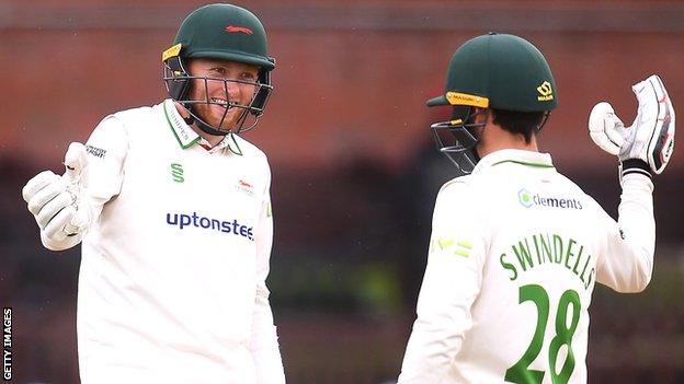 Ed Barnes and Harry Swindells celebrate a batting milestone at Somerset