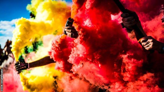 Detroit City fans holding pyrotechnic flares