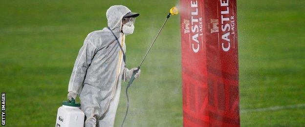 A stadium worker sanitising the post protectors at Ellis Park