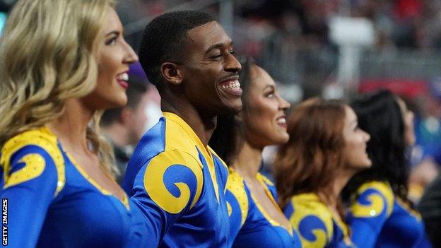 Rams cheerleader Quinton Peron smiles