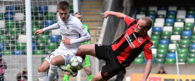 United defender Matthew Smyth attempts to keep out Jordan Owens of Crusaders